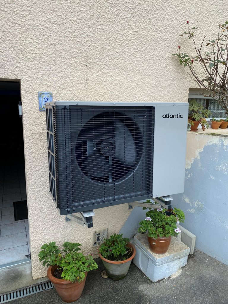 Installation unité extérieure pompe à chaleur Atlantic sur support mural en façade
